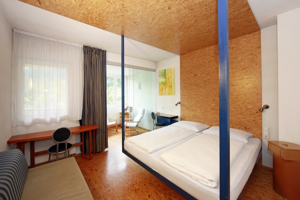 Rum med dubbelsng, soffa och skrivbord p hotell Pustertalerhof i Kiens, Dolomiterna.